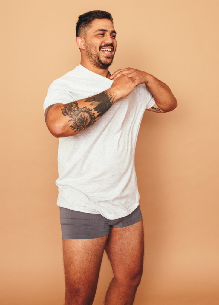 Young man taking his shirt off in a studio