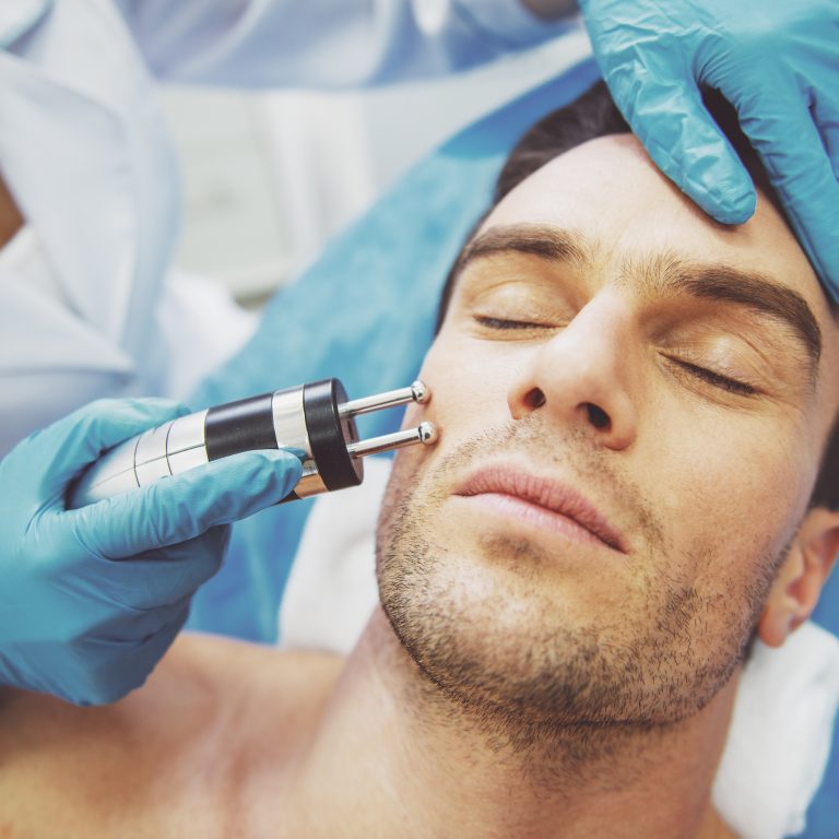 Man receiving a professional facial treatment at a skincare clinic.